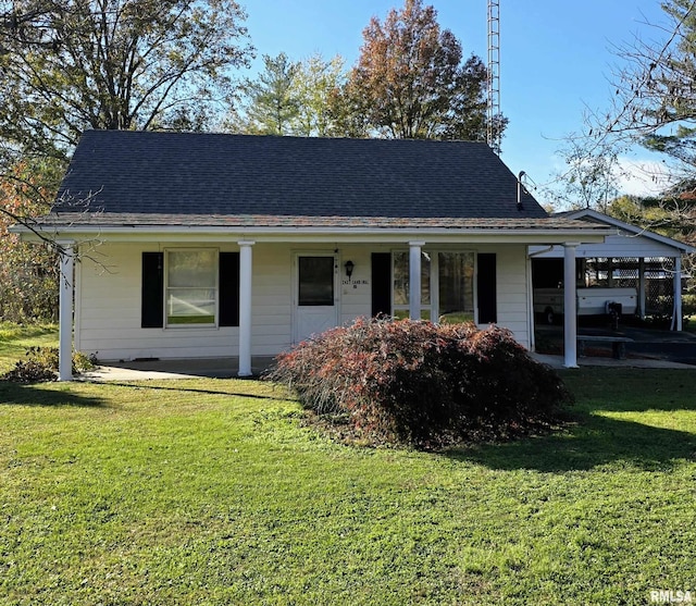 view of front of house with a carport and a front lawn