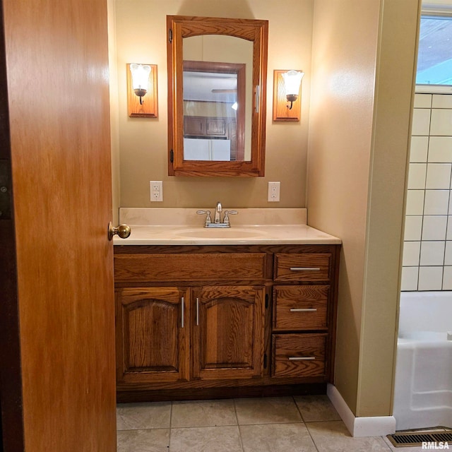 bathroom featuring tile patterned floors, a bathing tub, and vanity