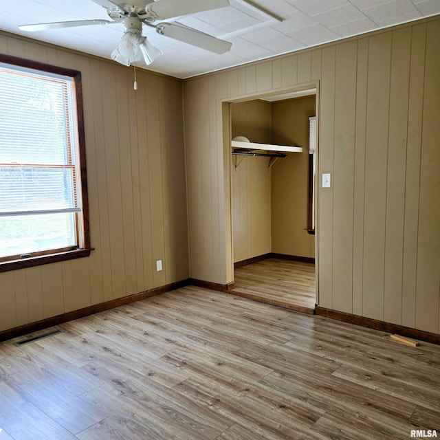 unfurnished bedroom featuring light hardwood / wood-style floors, a closet, and ceiling fan