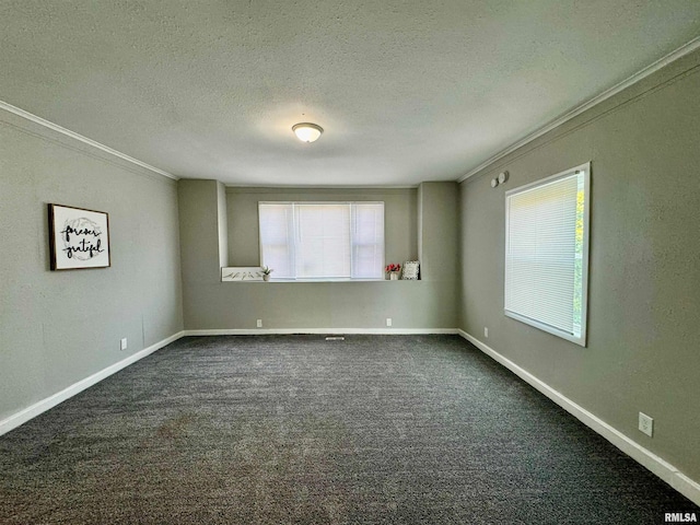 empty room with dark carpet, a textured ceiling, and ornamental molding