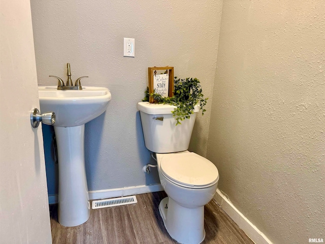 bathroom featuring hardwood / wood-style flooring, toilet, and sink