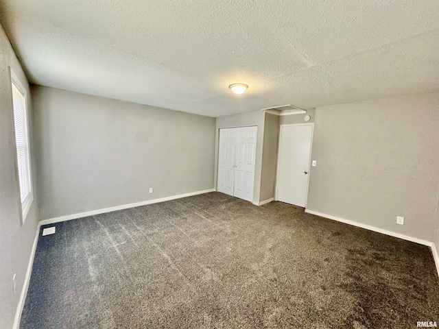 unfurnished bedroom featuring a textured ceiling, carpet floors, and multiple windows