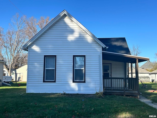 view of side of property with a lawn and a porch