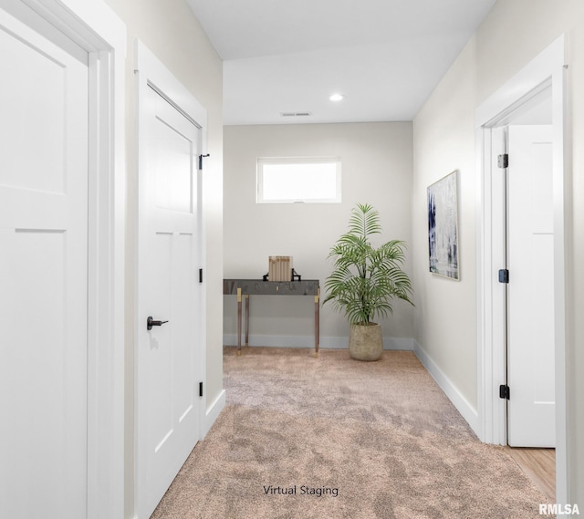 hall featuring light colored carpet