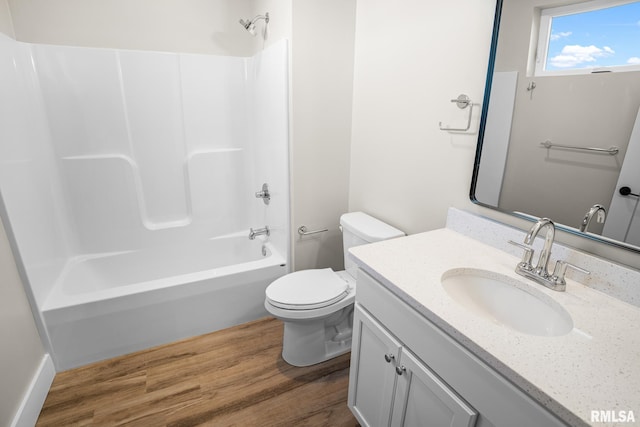 full bathroom with hardwood / wood-style floors, vanity, shower / bath combination, and toilet