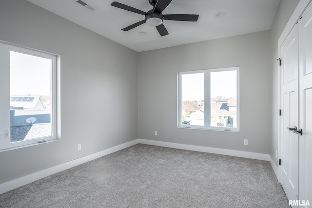 spare room with ceiling fan and light colored carpet