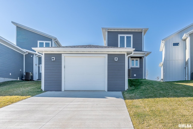 view of front of home with a garage, a front yard, and central AC