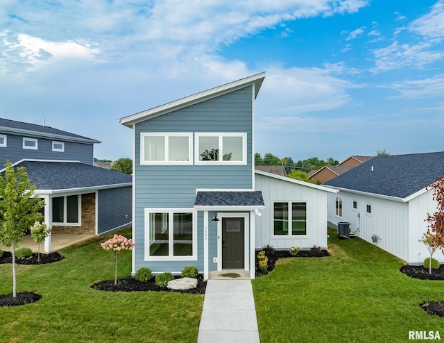 view of front of home with central AC unit and a front yard