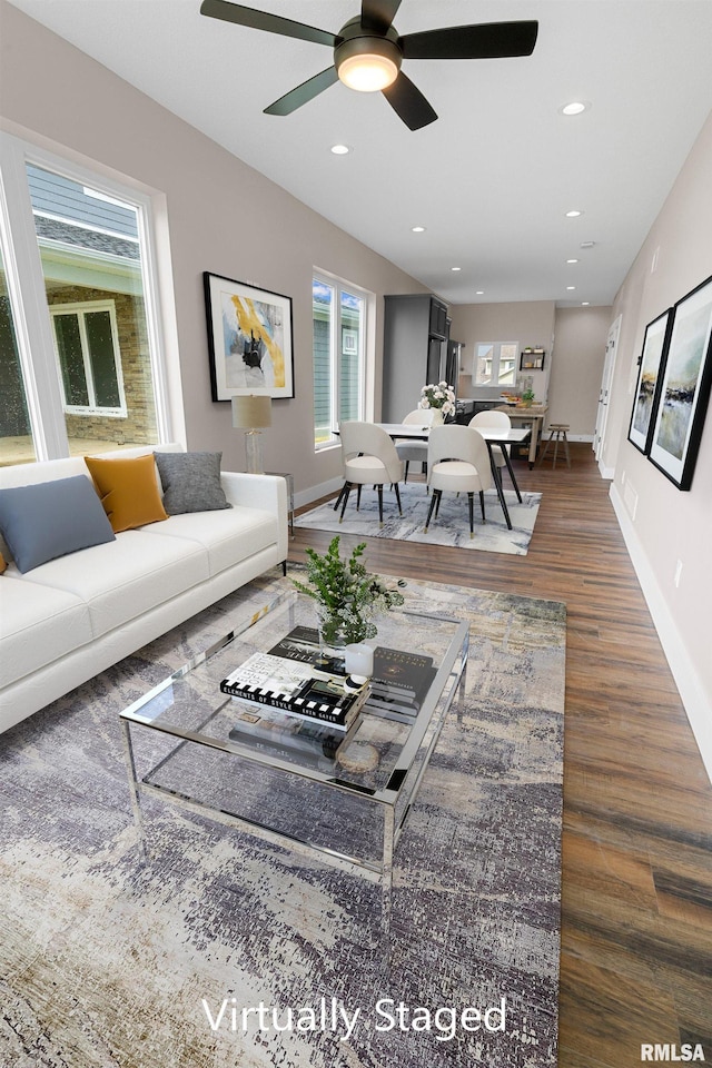 living room featuring ceiling fan and dark wood-type flooring