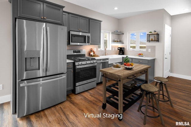 kitchen with gray cabinetry, dark hardwood / wood-style floors, sink, and appliances with stainless steel finishes