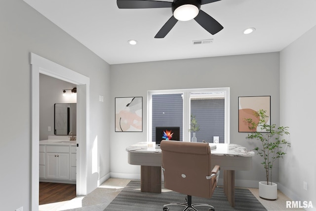 home office featuring ceiling fan, dark carpet, a healthy amount of sunlight, and sink