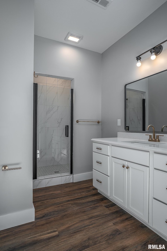 bathroom with vanity, an enclosed shower, and hardwood / wood-style flooring