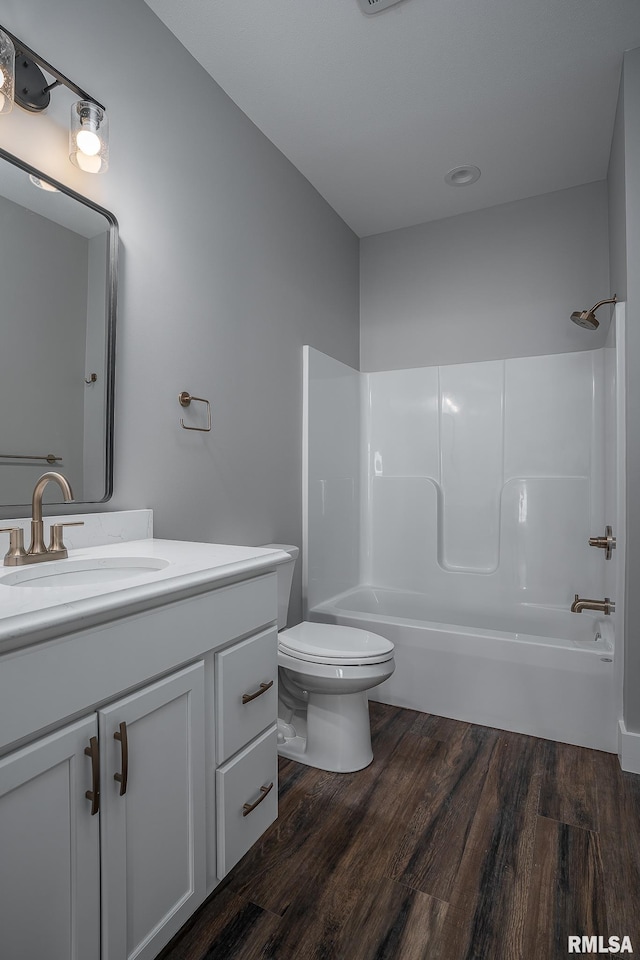 full bathroom with hardwood / wood-style flooring, vanity, toilet, and shower / washtub combination