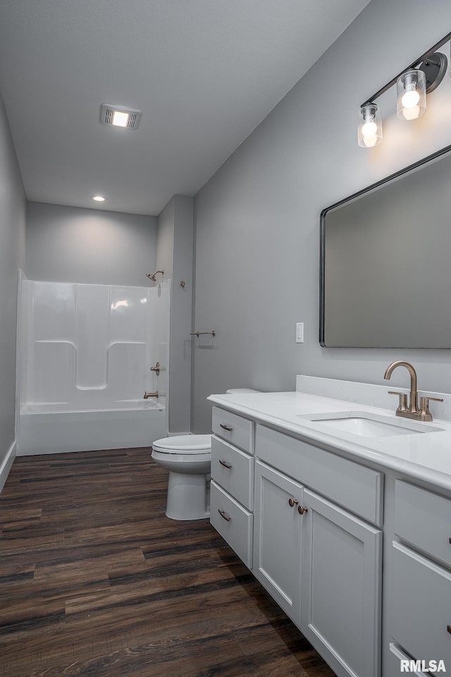 full bathroom featuring hardwood / wood-style flooring, vanity, toilet, and shower / washtub combination