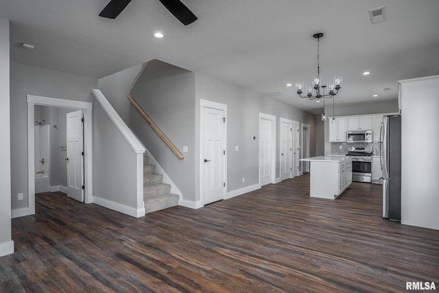 kitchen with white cabinetry, dark hardwood / wood-style floors, decorative light fixtures, a kitchen island, and appliances with stainless steel finishes