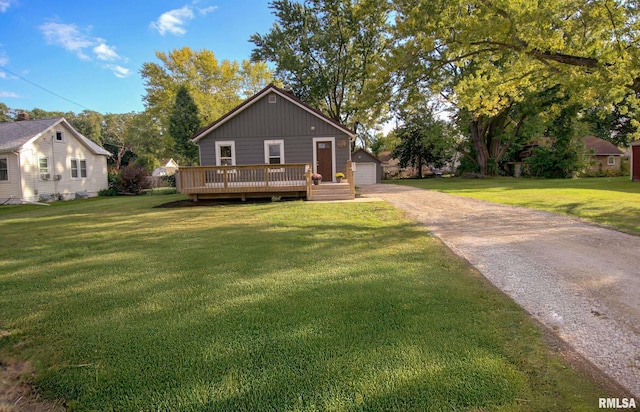 view of front of property with a garage, a front lawn, an outdoor structure, and a wooden deck