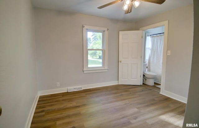 unfurnished bedroom featuring connected bathroom, light hardwood / wood-style flooring, and ceiling fan