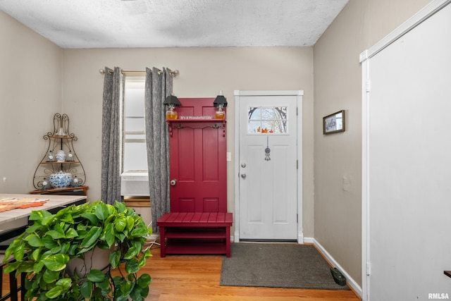 foyer entrance with a textured ceiling and light hardwood / wood-style flooring