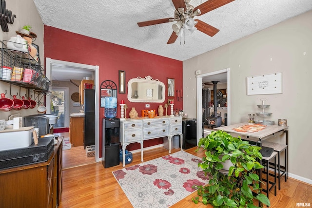 dining area with ceiling fan, light hardwood / wood-style floors, and a textured ceiling