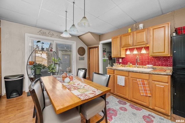 kitchen featuring a paneled ceiling, decorative light fixtures, backsplash, and sink