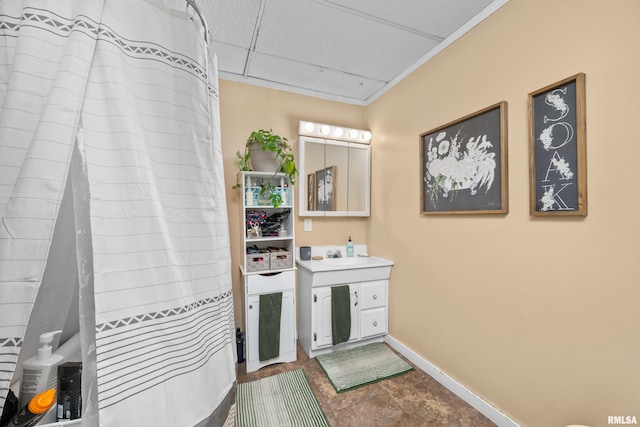 interior space featuring vanity, a drop ceiling, and crown molding