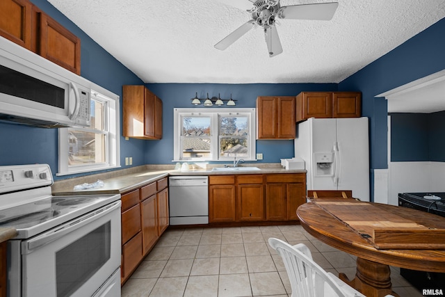 kitchen with ceiling fan, sink, a textured ceiling, white appliances, and light tile patterned flooring