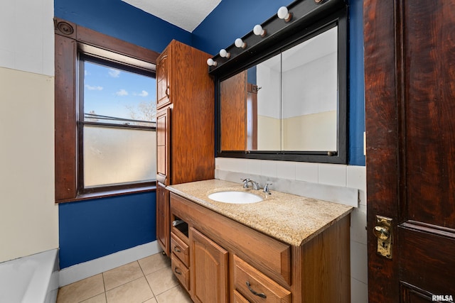 bathroom featuring tile patterned flooring, vanity, a tub to relax in, and a textured ceiling