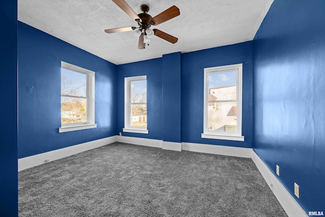 carpeted spare room with ceiling fan and a textured ceiling