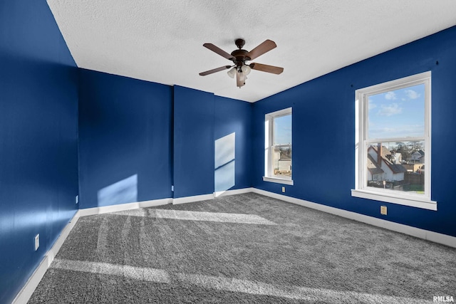 carpeted empty room featuring ceiling fan and a textured ceiling