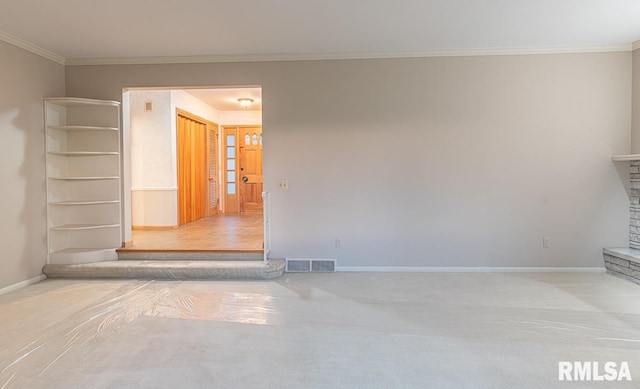 empty room with crown molding and a stone fireplace