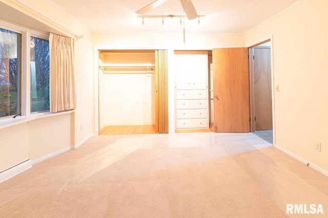 unfurnished bedroom with light carpet, a closet, ornamental molding, and rail lighting