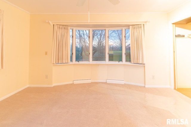 carpeted spare room with ceiling fan, a baseboard heating unit, and ornamental molding