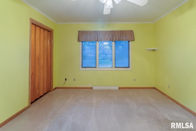 carpeted spare room with ceiling fan and crown molding