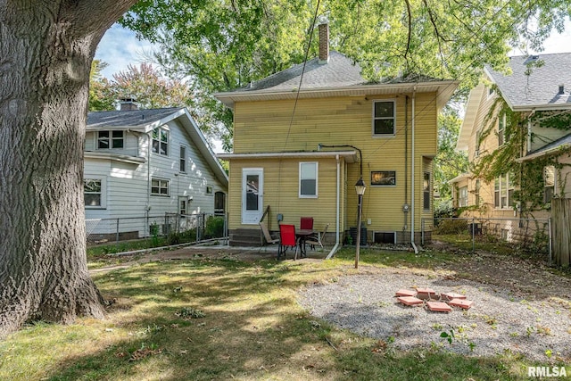 rear view of house with a lawn and central AC