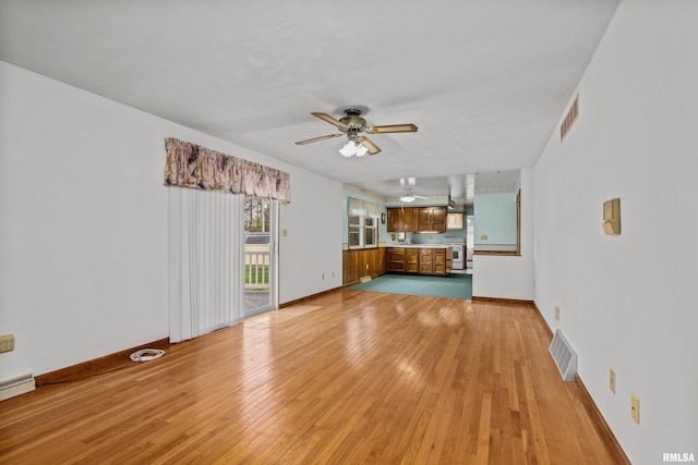 unfurnished living room featuring ceiling fan and light hardwood / wood-style flooring