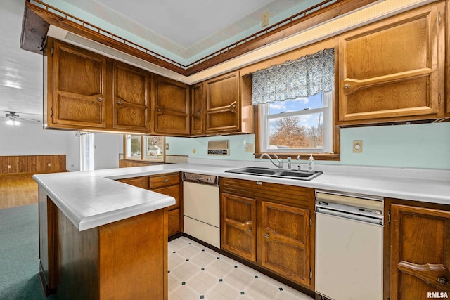 kitchen featuring kitchen peninsula, white dishwasher, and sink