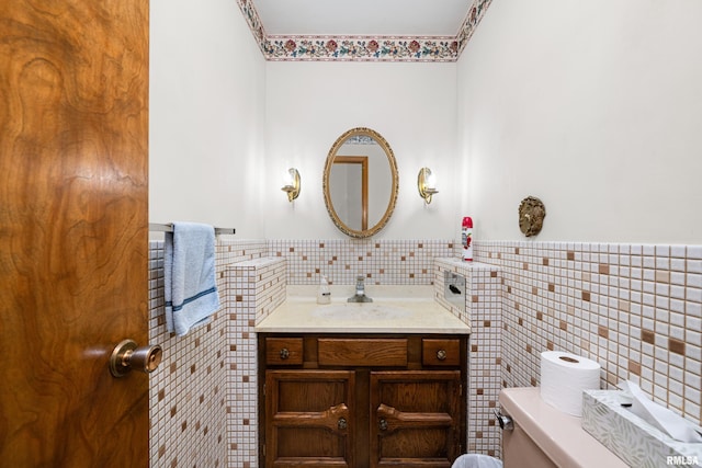 bathroom featuring vanity, toilet, and tile walls