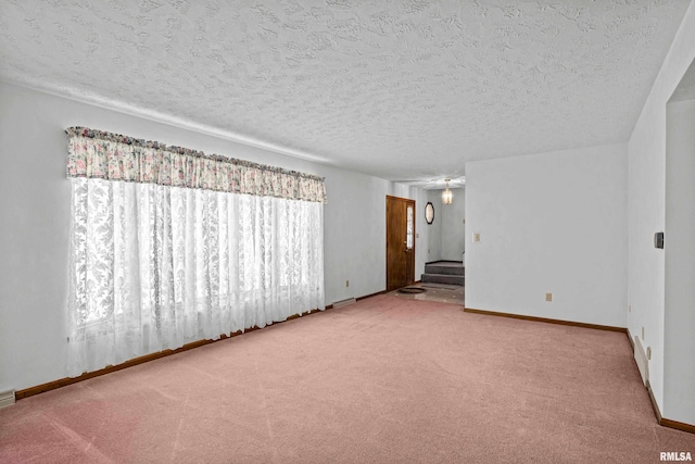 carpeted spare room with a textured ceiling