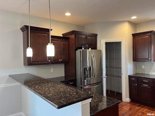 kitchen with kitchen peninsula, stainless steel fridge with ice dispenser, decorative light fixtures, and tasteful backsplash