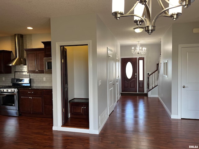 entrance foyer with a notable chandelier, dark hardwood / wood-style flooring, and a textured ceiling