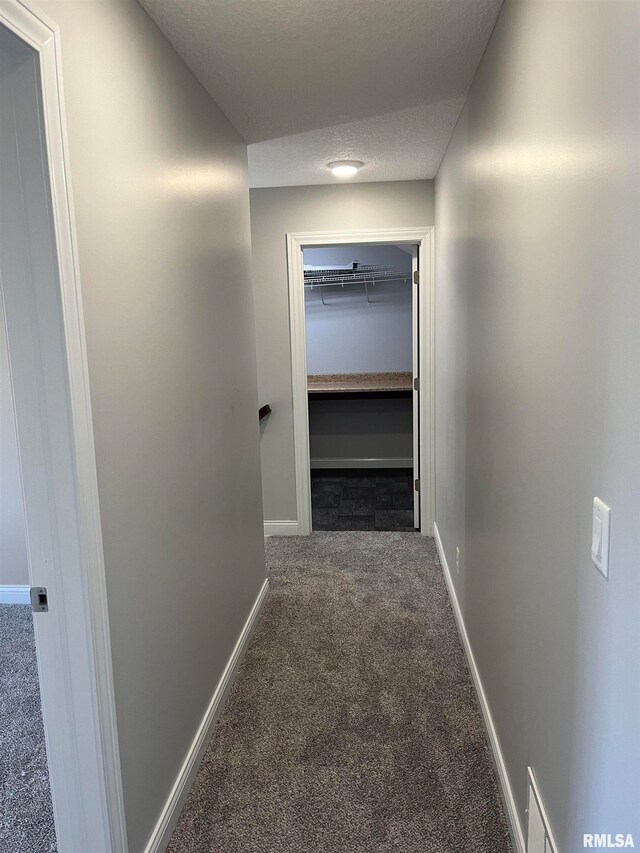 corridor featuring carpet and a textured ceiling