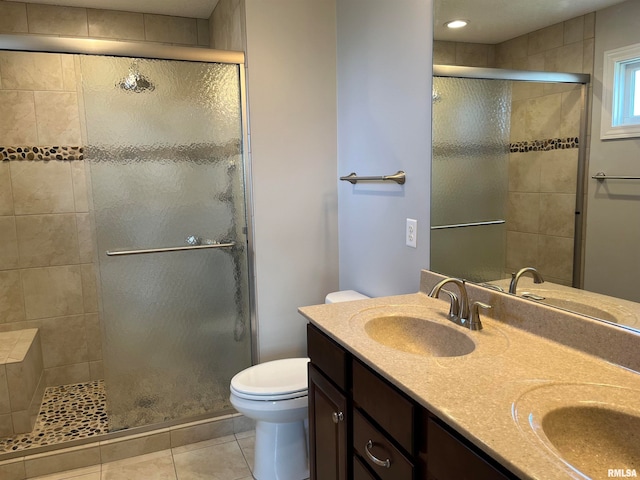 bathroom featuring tile patterned flooring, vanity, an enclosed shower, and toilet