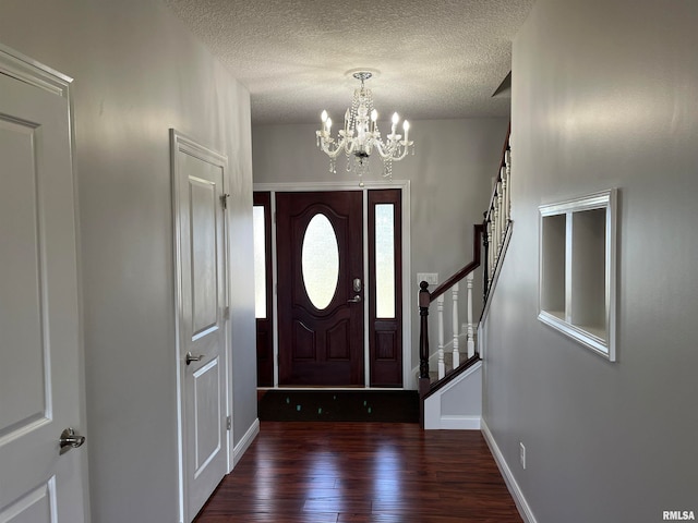 foyer featuring dark hardwood / wood-style floors, a textured ceiling, and an inviting chandelier