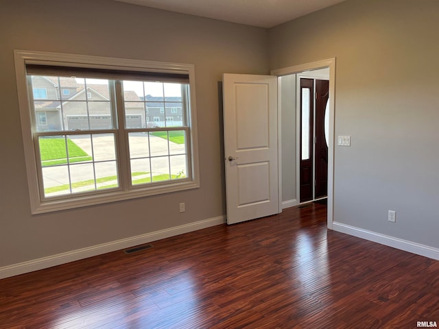 unfurnished room with dark hardwood / wood-style flooring