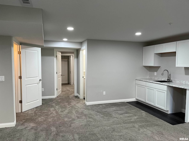 kitchen featuring sink, white cabinets, and dark colored carpet