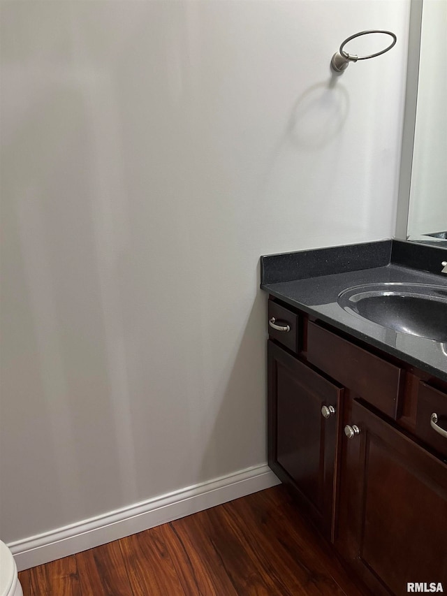 bathroom featuring vanity, hardwood / wood-style flooring, and toilet