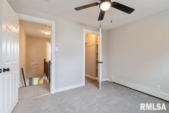 unfurnished bedroom featuring ceiling fan, light colored carpet, baseboard heating, and a closet