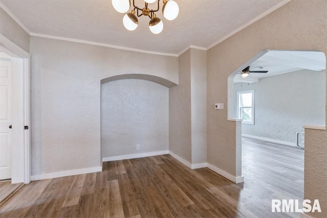 spare room with hardwood / wood-style floors, ceiling fan with notable chandelier, and ornamental molding