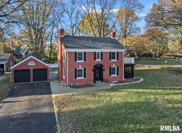 view of front of property featuring an outbuilding, a garage, and a front yard