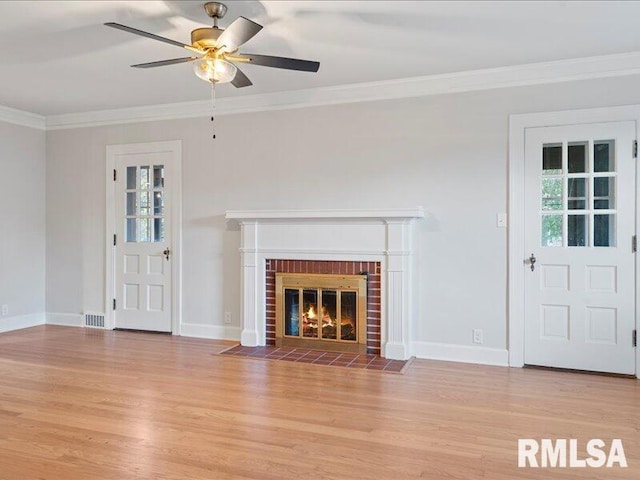 unfurnished living room with a fireplace, light wood-type flooring, ceiling fan, and crown molding